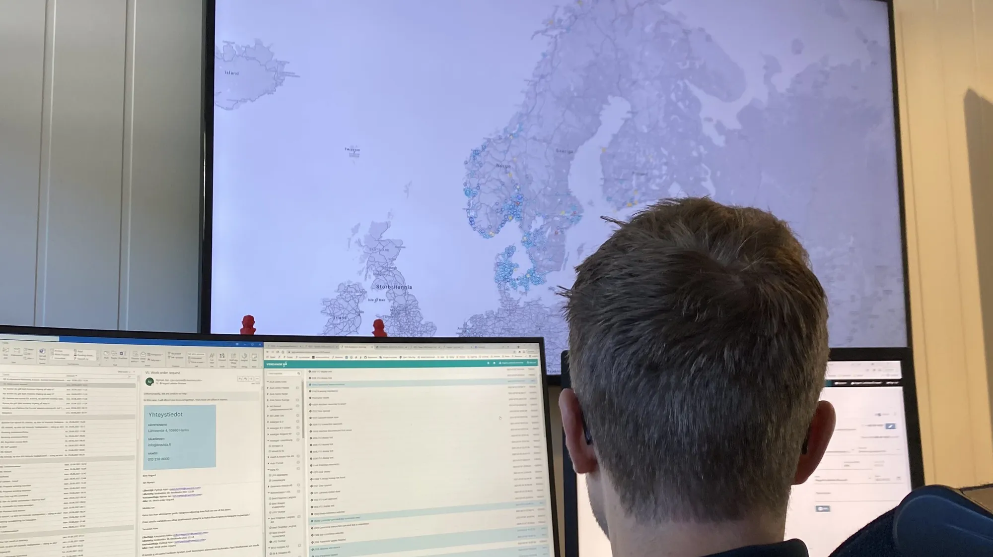 Vendanor employee at a desk viewing a large map of Europe and dashboards on multiple screens.