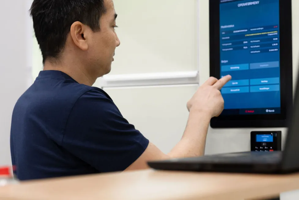 Vendanor employee performing quality control at a touchscreen workstation.