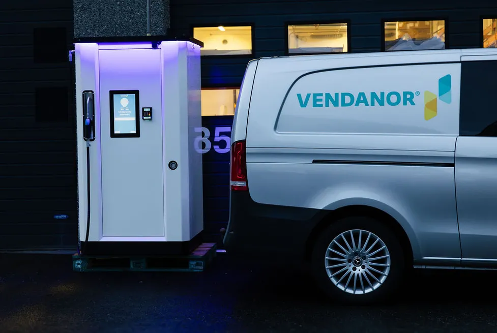 Vendanor Washer Fluid Dispenser with lit display beside a branded Vendanor service van at night.